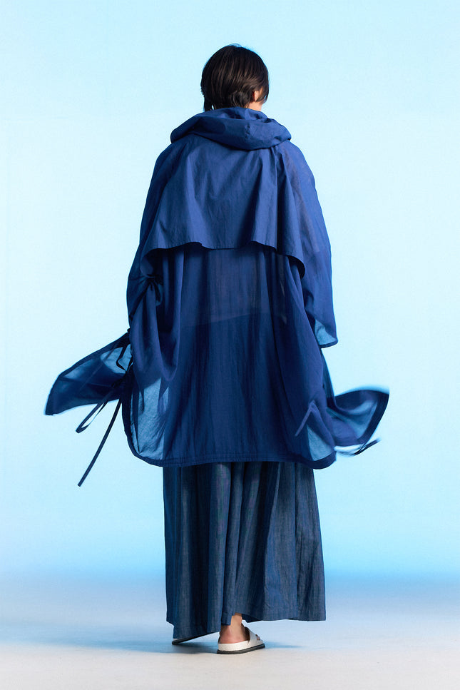 Model wearing the Nayeli Poncho with an oversized, hooded silhouette, featuring a hidden button opening and adjustable drawstring details that create a soft, flowing shape for modern everyday layering.
