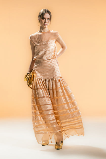 Model wearing the Nancy Top with a straight silhouette and clean hem, featuring a lightly transparent upper bodice contrasted by a silk-appliquéd lower section, styled tucked into trousers for an elegant look.
