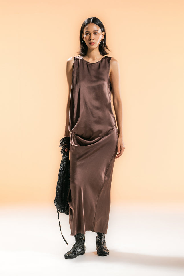 Model wearing BIASA Naoka Dress in pure silk, featuring a fluid silhouette, soft draping, and a side slit, creating an elegant and minimal look.
