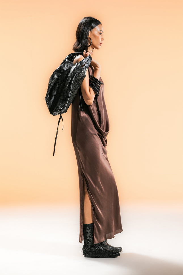 Model wearing BIASA Naoka Dress in pure silk, featuring a fluid silhouette, soft draping, and a side slit, creating an elegant and minimal look.