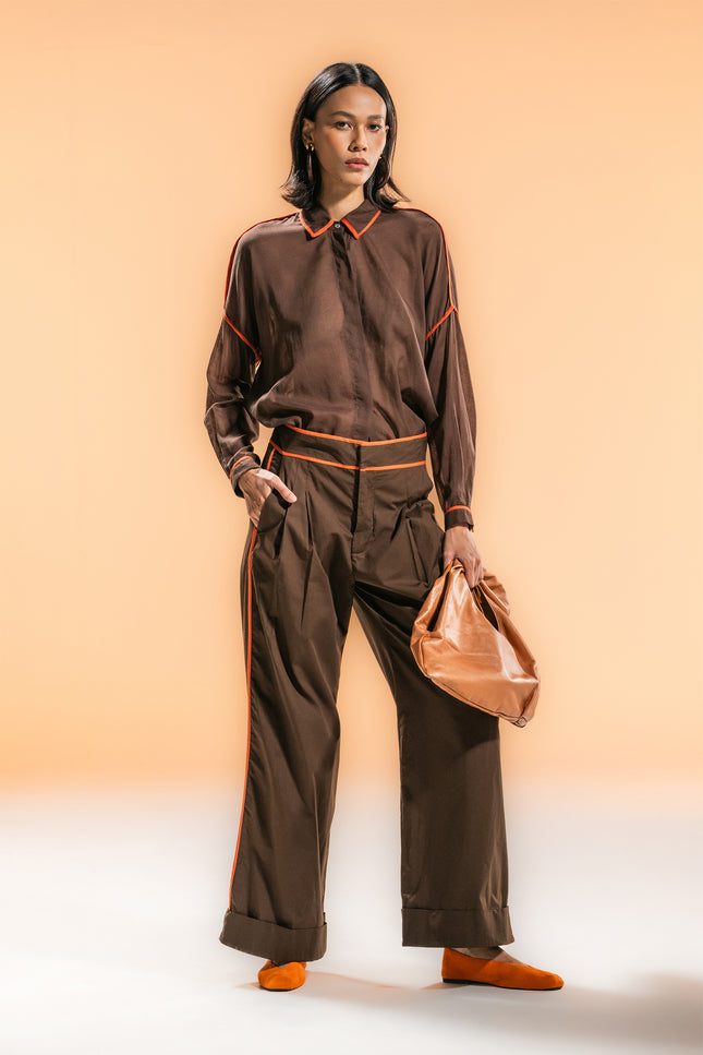 Model wearing the Natilie Shirt with a square-shaped, relaxed silhouette, long cuffed sleeves, and contrast binding details, styled in lightweight cotton for a modern, effortless look.