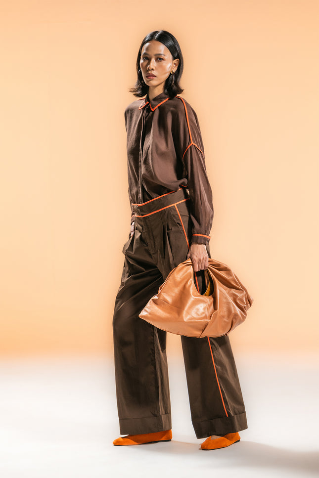 Model wearing the Natilie Shirt with a square-shaped, relaxed silhouette, long cuffed sleeves, and contrast binding details, styled in lightweight cotton for a modern, effortless look.