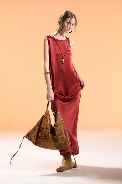 Model wearing BIASA Naoka Dress in pure silk, featuring a fluid silhouette, soft draping, and a side slit, creating an elegant and minimal look.