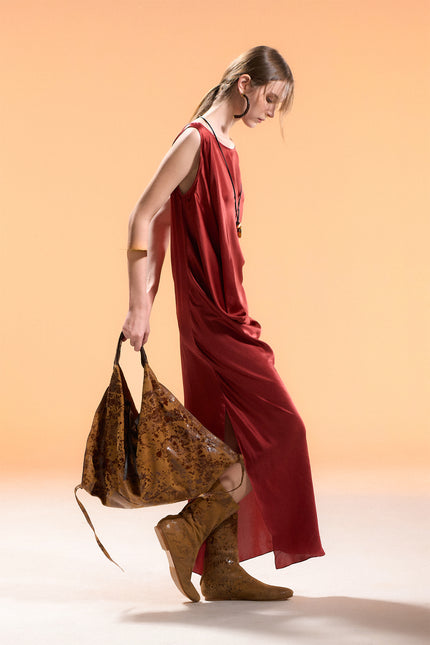 Model wearing BIASA Naoka Dress in pure silk, featuring a fluid silhouette, soft draping, and a side slit, creating an elegant and minimal look.