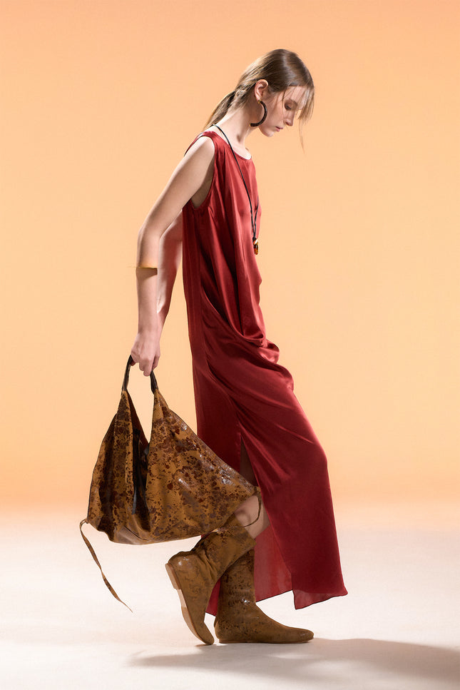 Model wearing BIASA Naoka Dress in pure silk, featuring a fluid silhouette, soft draping, and a side slit, creating an elegant and minimal look.