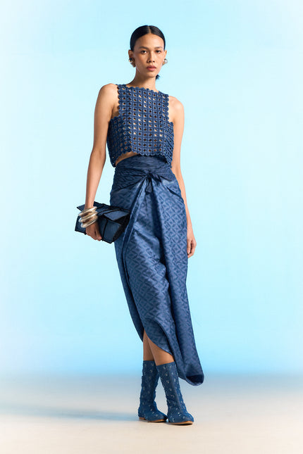 Model wearing a handloom silk sarong in deep indigo, featuring traditional Garut geometric tenun weaving, styled as a draped skirt.