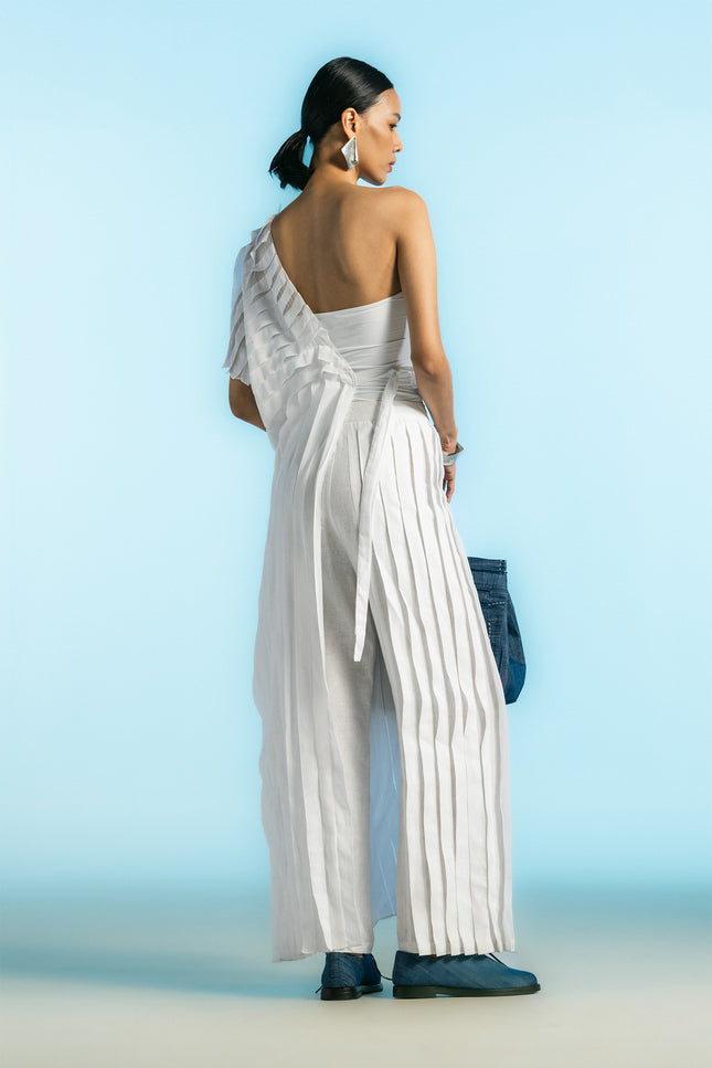 Model wearing Nyma Dress in lightweight cotton, featuring a sculptural one-shoulder silhouette, layered pleats, asymmetrical design, and adjustable side tie.