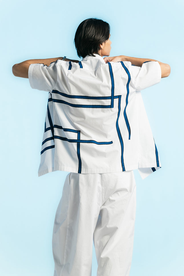 Model wearing Noga Camp Shirt in lightweight cotton, featuring reflected stripe applique, a regular-fit silhouette, and a seamless patch pocket.