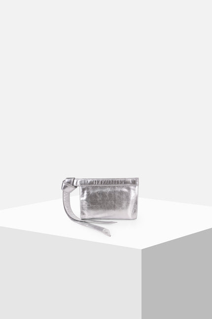 Neri Clutch with a structured rectangular silhouette, cowhide leather exterior, handloom lurik lining, leather patch pocket, double magnetic closure, and knotted strap detail.
