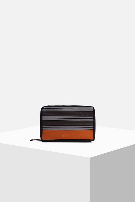 Canvas pouch with bold tarpaulin stripe appliqué, zipper closure, contrast handle, and internal mesh pocket.
