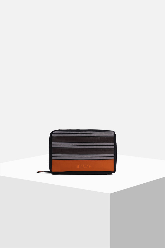 Canvas pouch with bold tarpaulin stripe appliqué, zipper closure, contrast handle, and internal mesh pocket.