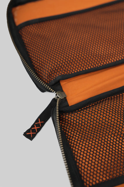 Canvas pouch with bold tarpaulin stripe appliqué, zipper closure, contrast handle, and internal mesh pocket.