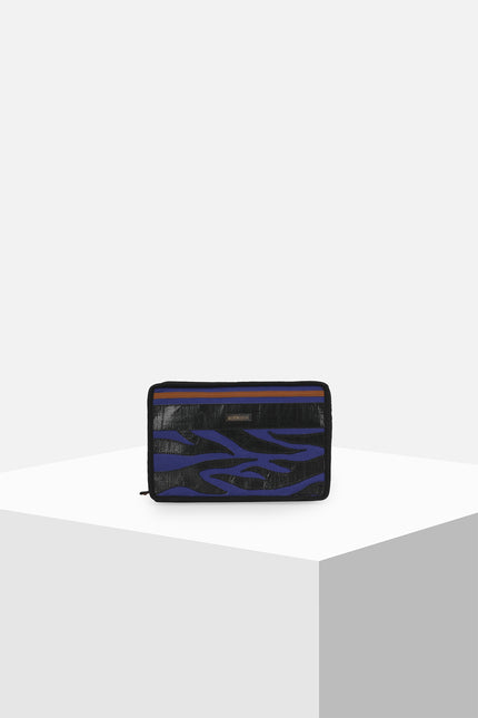 Canvas clutch featuring zebra tarpaulin appliqué, zipper closure, contrast handle, and internal mesh pocket.