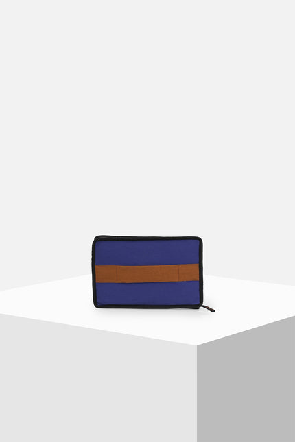 Canvas clutch featuring zebra tarpaulin appliqué, zipper closure, contrast handle, and internal mesh pocket.