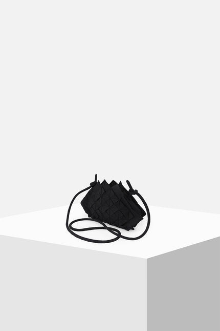 Nemesia Mini Sling Bag made from cotton with origami-inspired geo flower appliqué, featuring a detachable spaghetti strap for crossbody or handheld use.