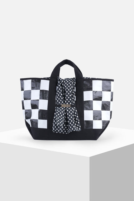 Black and white checkered terpal tote bag with canvas straps, cotton block print accent, and internal pocket.