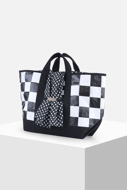 Black and white checkered terpal tote bag with canvas straps, cotton block print accent, and internal pocket.