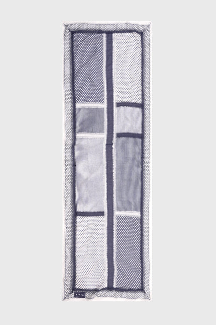 Model wearing the Ondrey Scarf in 100% cotton, featuring assorted handmade block-print patterns and double-color fringe stripes along the center and edges.